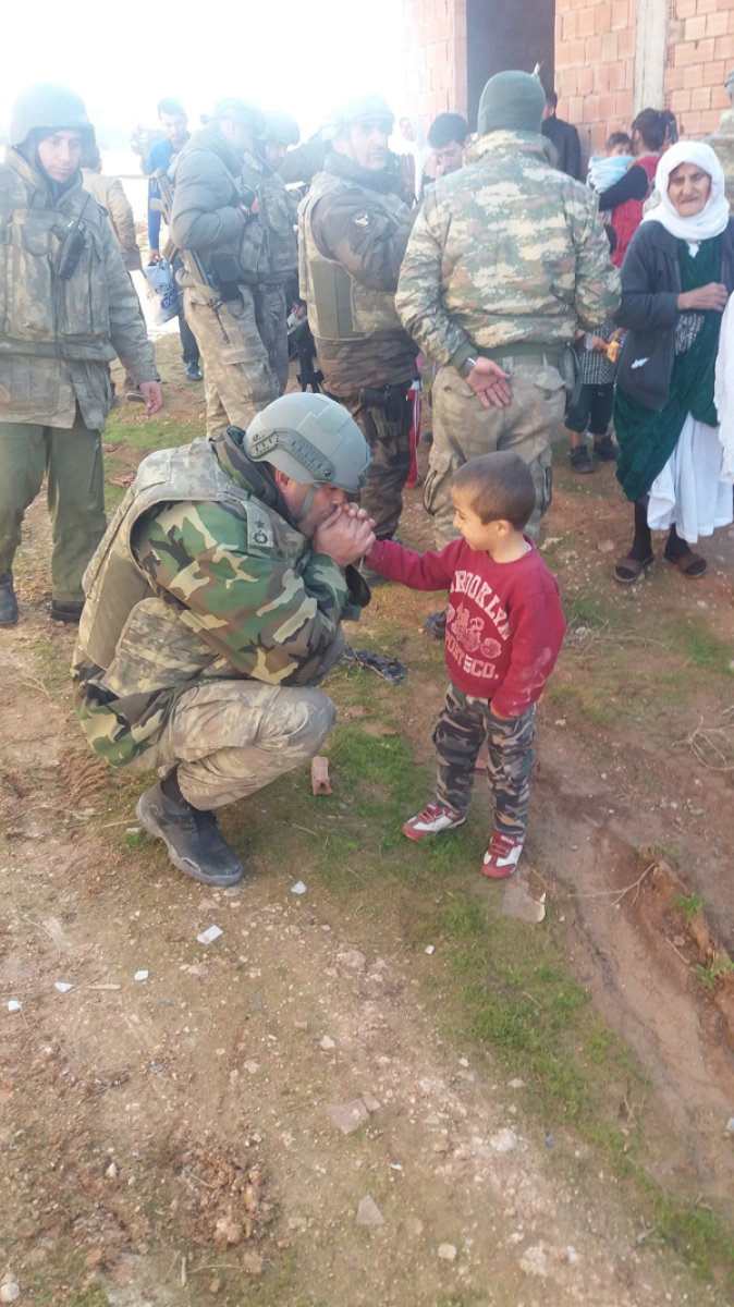 Silopi'de bir tabur komutanı üşüyen bir çocuğun ellerini ısıtıyor